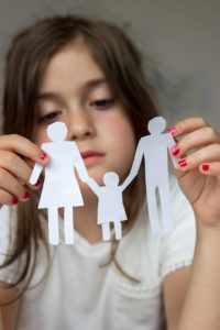 little girl holding paper cutout of family