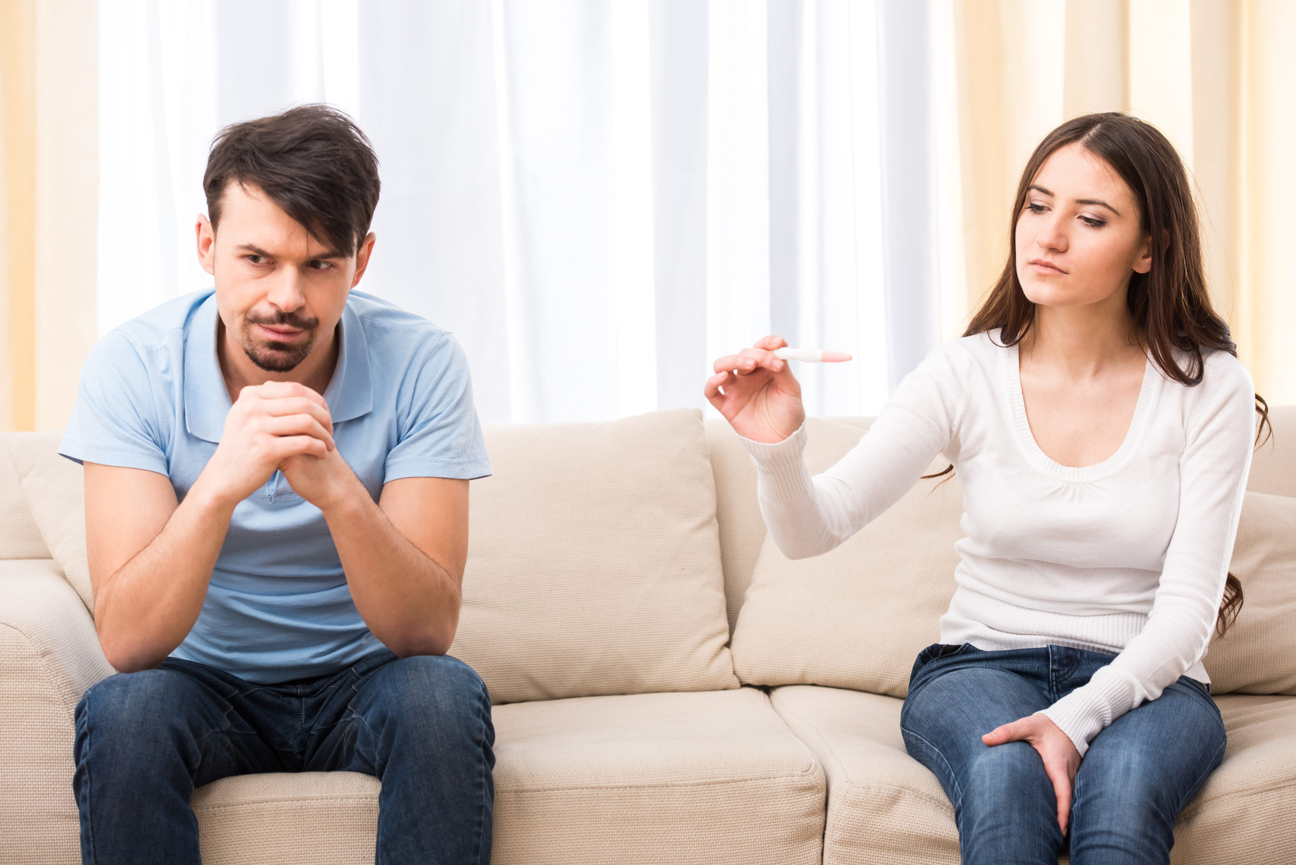 couple looking at pregnancy test visibly upset