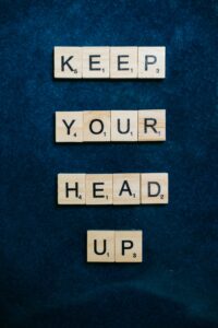 Scrabble letters that say "KEEP YOUR HEAD UP"