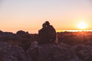 Couple sitting on the beach watching a sunset