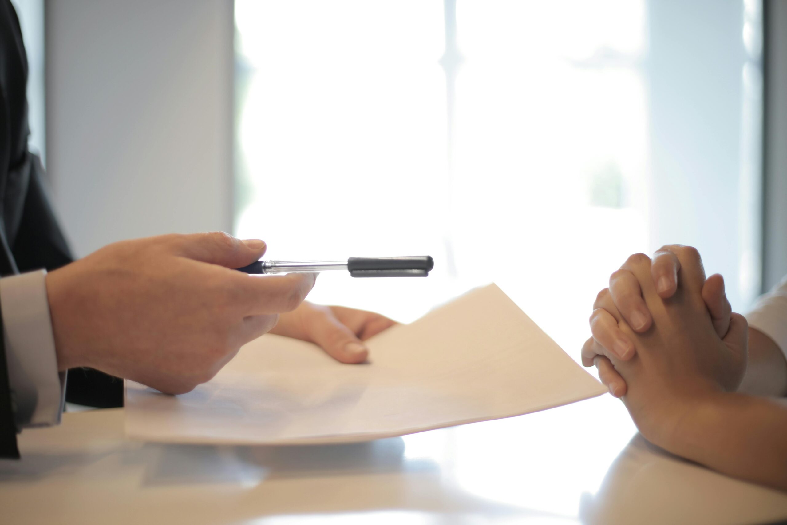 Man handing a document to another person to sign