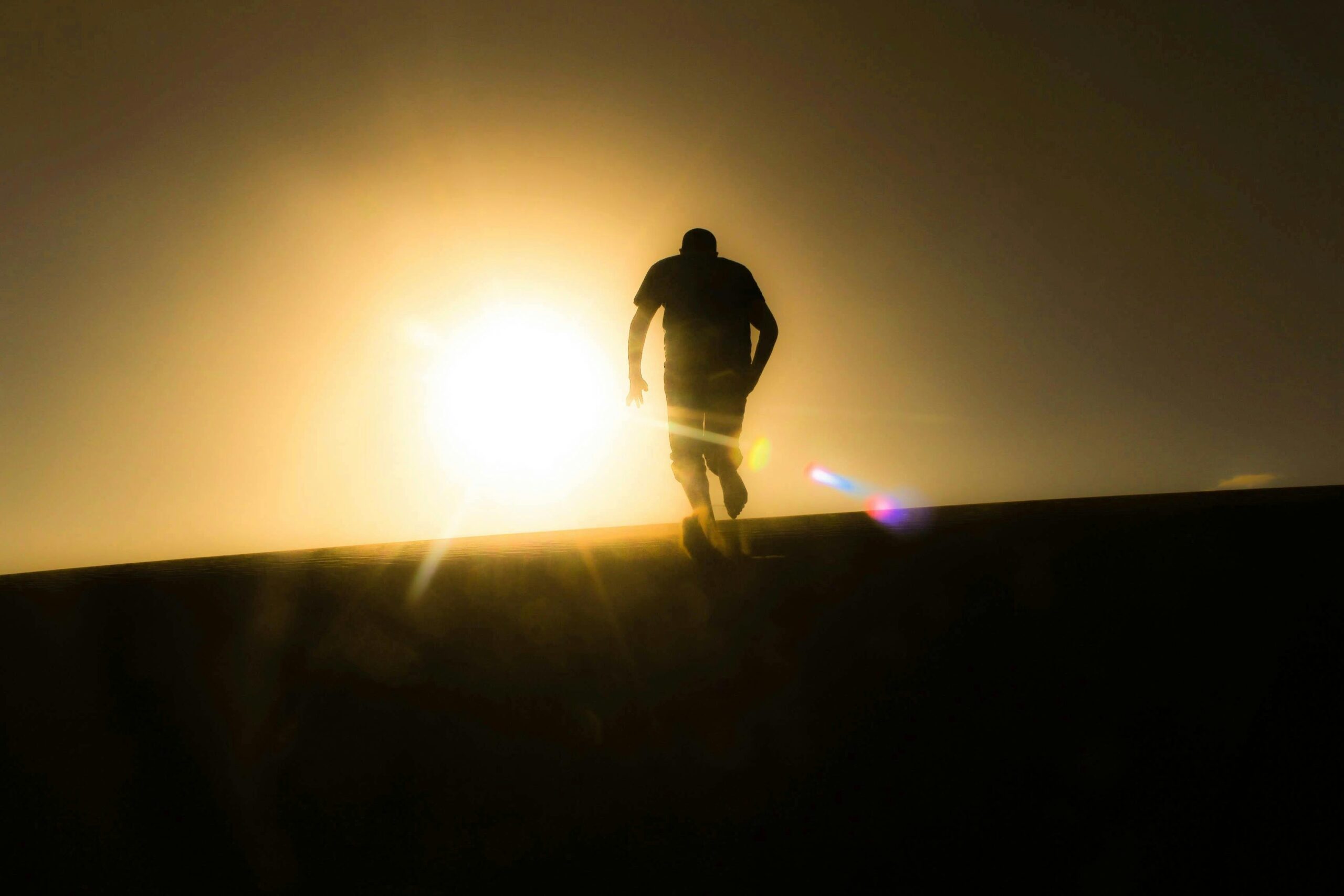 Person walking toward a sunrise - A person engaging in a healthy outdoor hobby like hiking to improve mental well-being during a divorce.