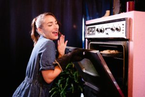 Woman getting something out of vintage oven