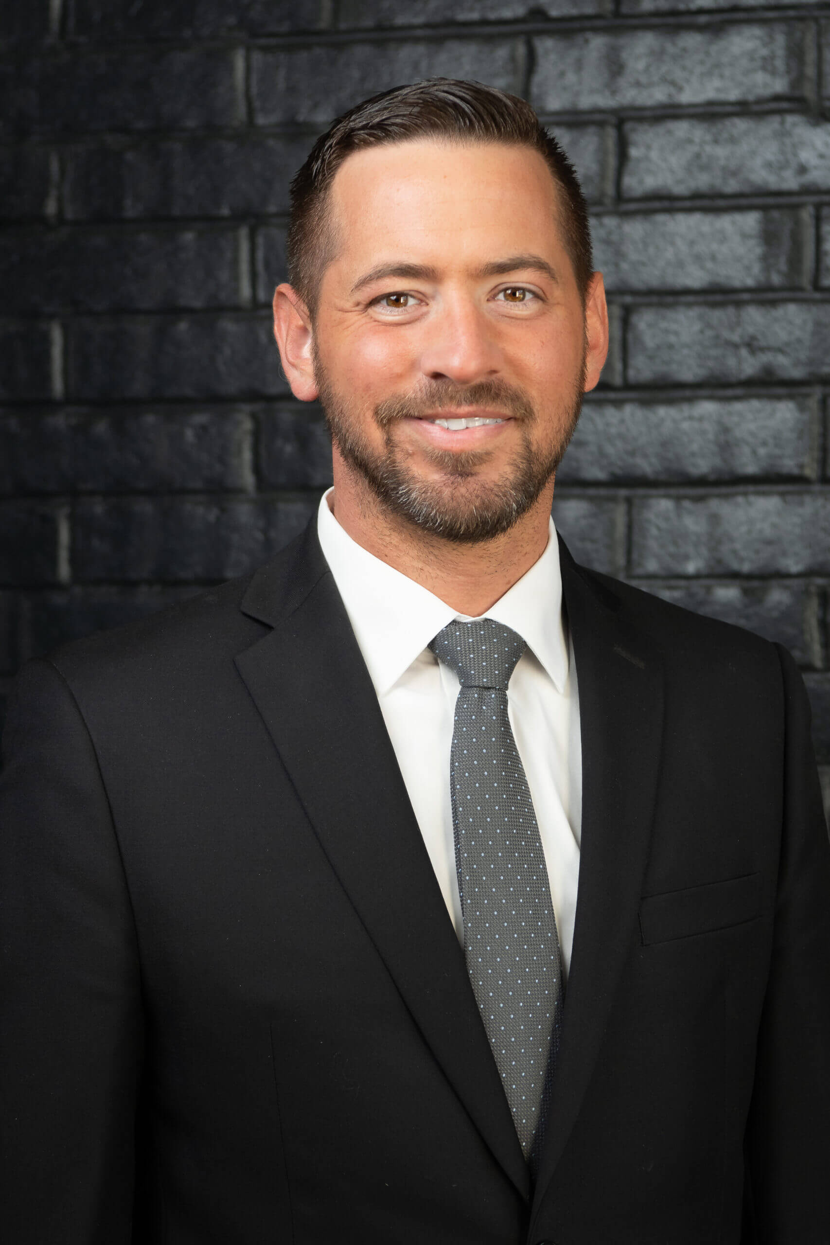 Managing Attorney, Luke Shaw | Image of Lawyer standing in front of a brick wall | Contact Coil Law Domestic Litigation Professionals Today!