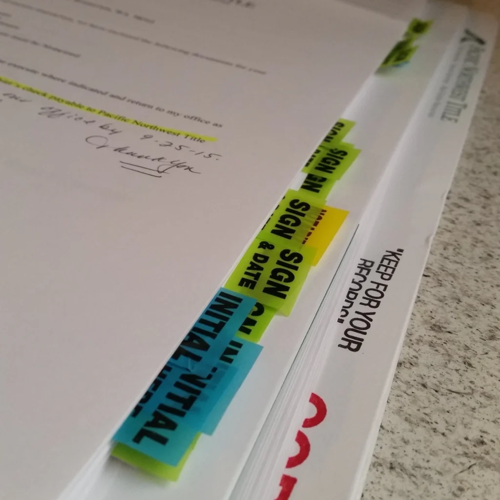 Prenuptial and postnuptial agreement paperwork with sign and initial tabs, representing next steps for Utah couples working with CoilLaw™